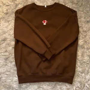 brown sweatshirt with red and white mushroom